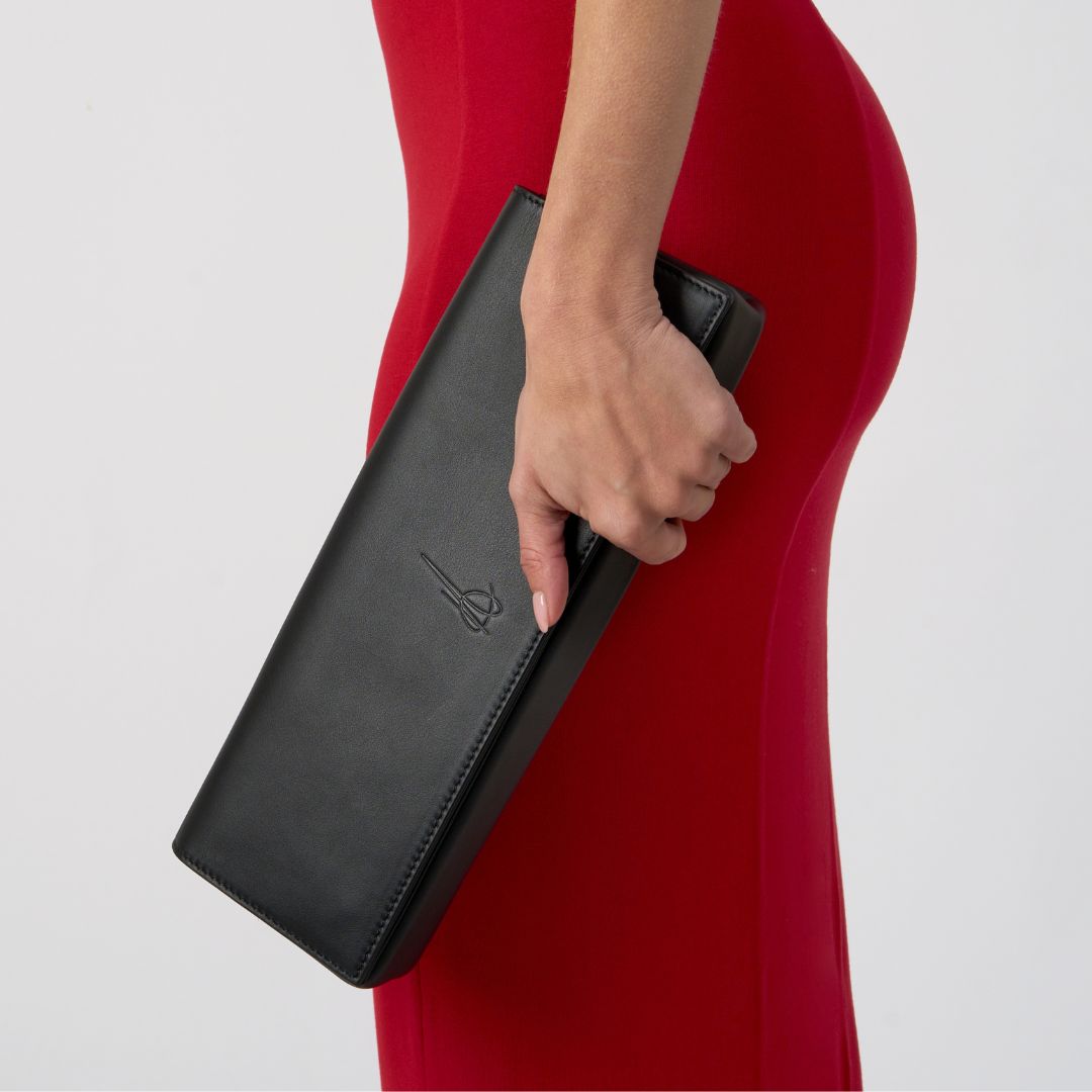 Aurora Bella clutch bag that is held by a woman #colour_black
